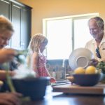 Grandfather and grandchildren prepare food in kitchen